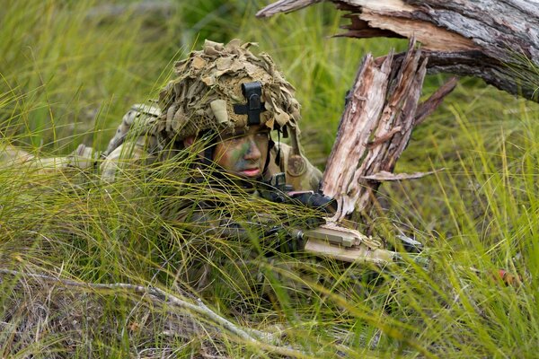 Soldat avec des armes dans une embuscade déguisée