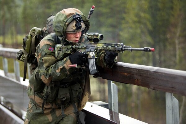 A soldier aims a gun at the bridge