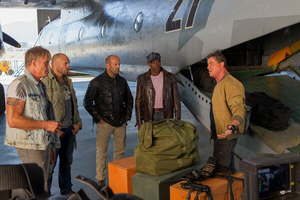 Aktorzy z filmu Niezniszczalni 3 stoją przy samolocie