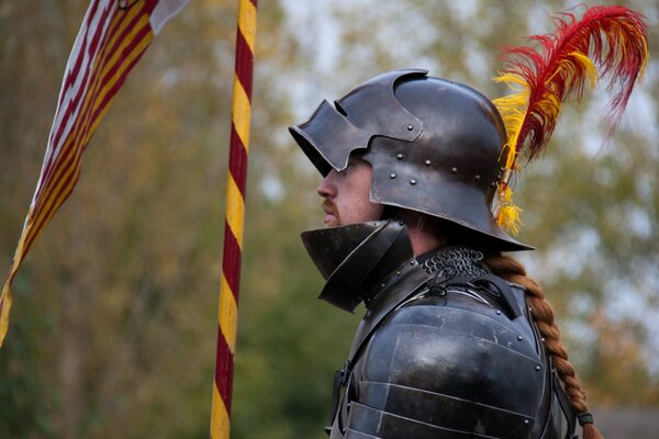 Cavaliere in armatura metallica con una piuma sul casco