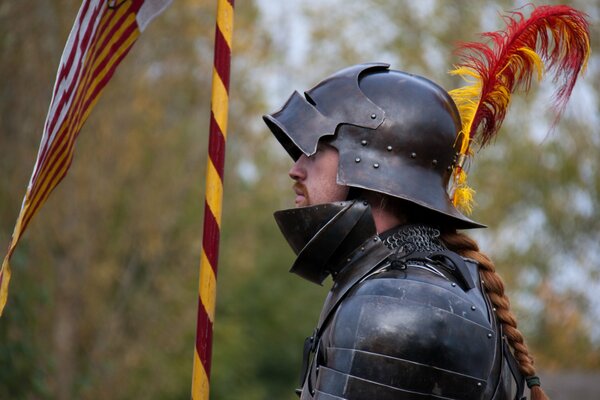 Рыцарь в металлических доспехах с пером на шлеме