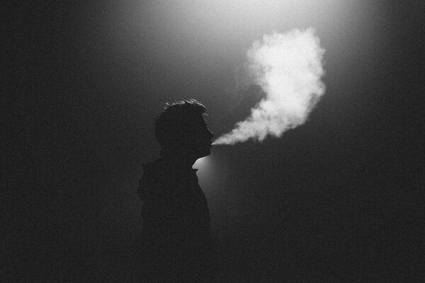 Silueta de un hombre. humo exhalado