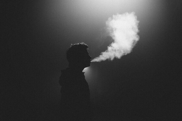 Silhouette d homme. exhalant la fumée
