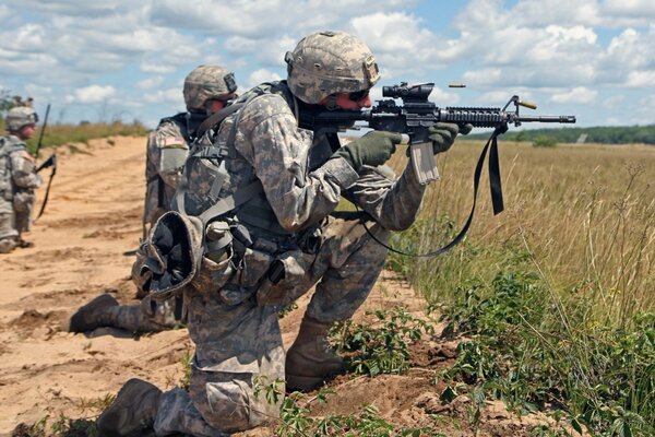 Tres soldados con armas en el campo