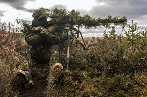 A soldier with a gun in a field near Lithuania