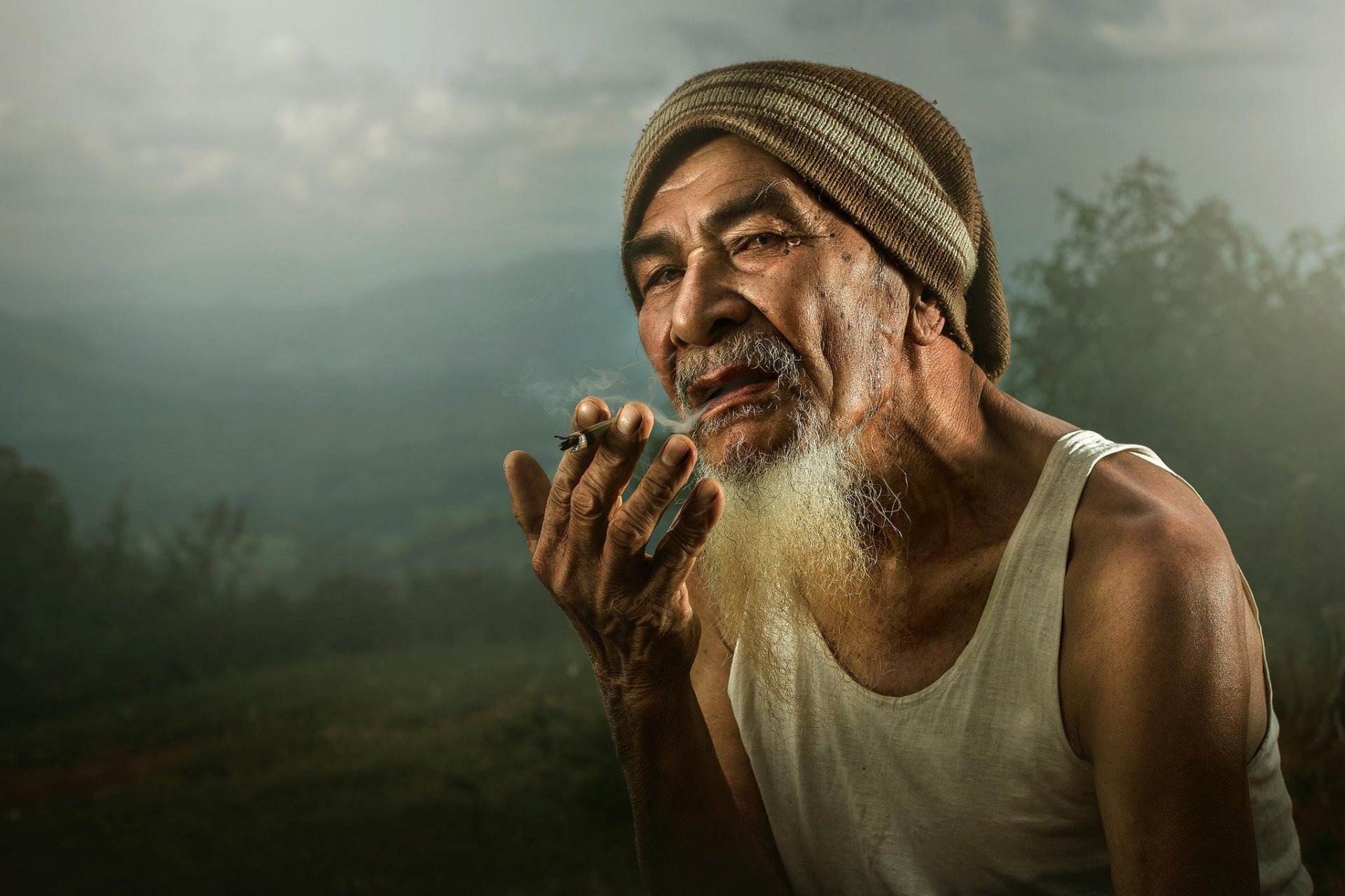 hombre viejo cool asiático fumar ojos mirada sombrero mano rudo dedos fuma cigarrillo cool asiático camiseta sombrero barba mirando mano hd