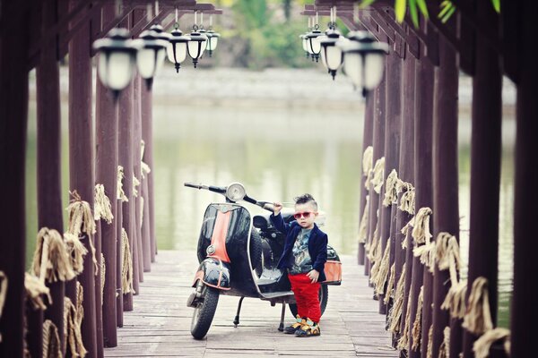 Garçon avec scooter sur fond de rivière