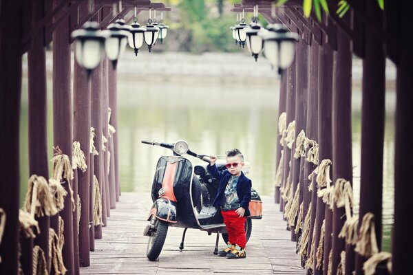 Ragazzo con scooter sullo sfondo del fiume