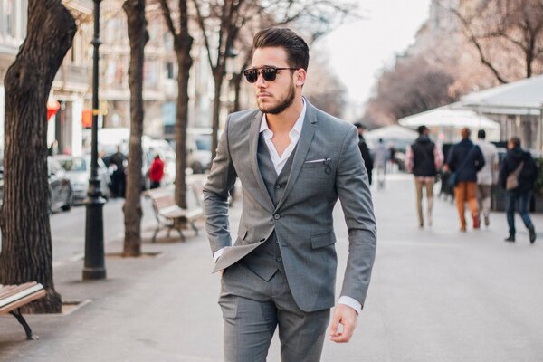 A man with glasses walking down the street