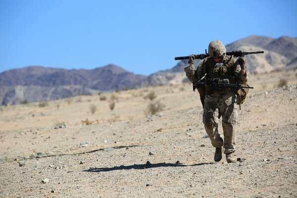 A military man in the desert with a gun