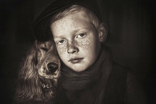 Portrait d un garçon avec des taches de rousseur et un chien à longues oreilles en couleur sépia