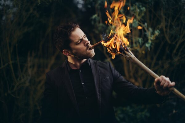 Un gars met le feu à une cigarette du feu d une branche