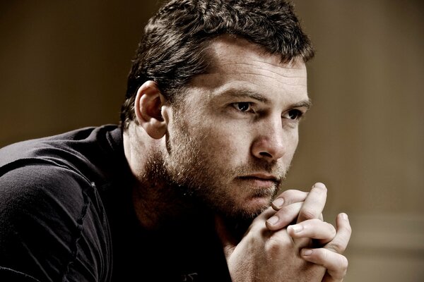 A man with a thoughtful look. actor sam worthington