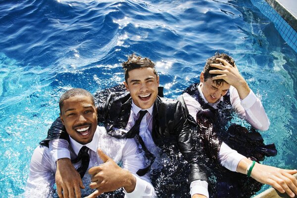 Three men in suits in the pool. Cheerful