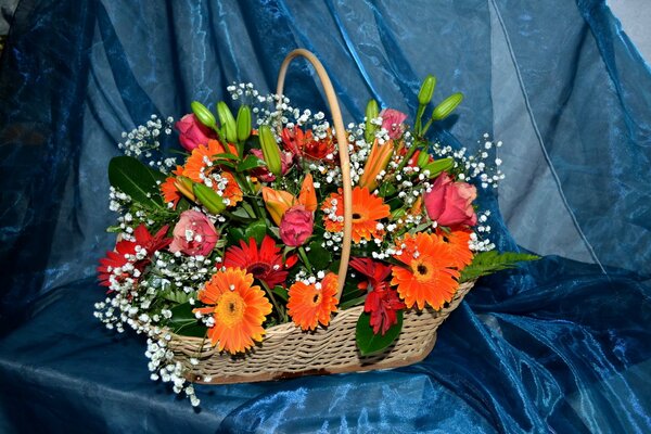 A basket of flowers on a blue bedspread