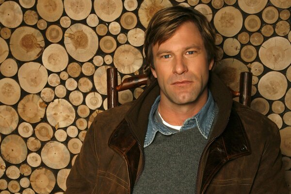 Aaron Eckhart on the background of firewood