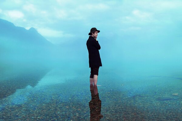 Mann mit Hut mit Reflexion im Wasser