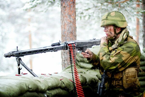 There is a soldier with a gun in the forest