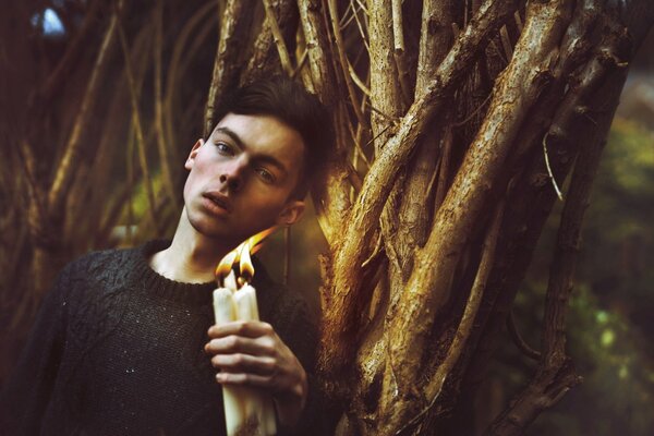 Photo shoot in the forest of a guy with candles