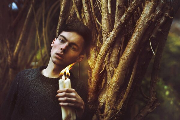 Sesión de fotos en el bosque de un chico con velas