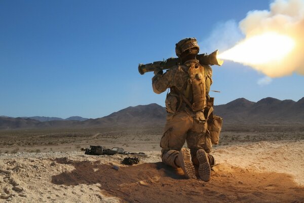 Un soldat se tient debout et tire avec un m136