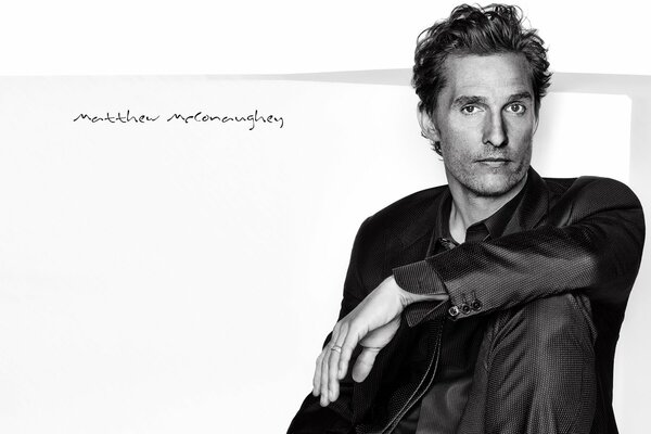 Matthew McConaughey se sienta en un traje negro