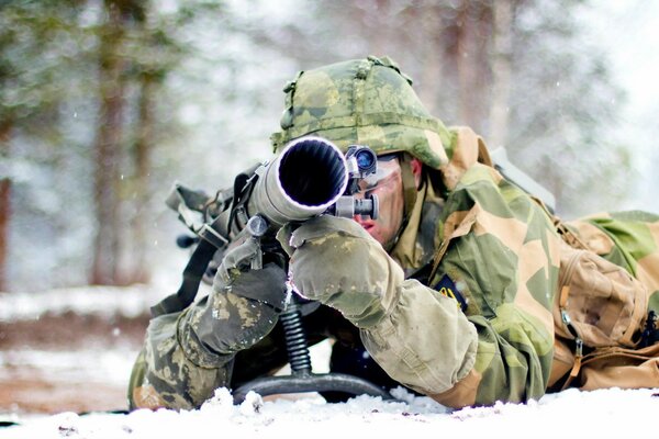 A soldier with a gun on the ground. Army