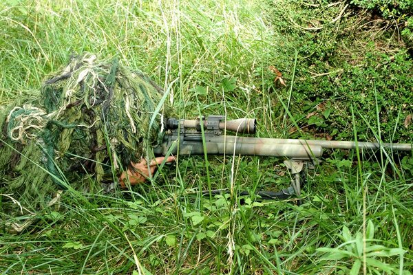 Scharfschütze in einem Anzug auf dem grünen Rasen