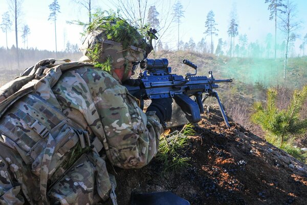 A soldier in a camouflage suit with a weapon