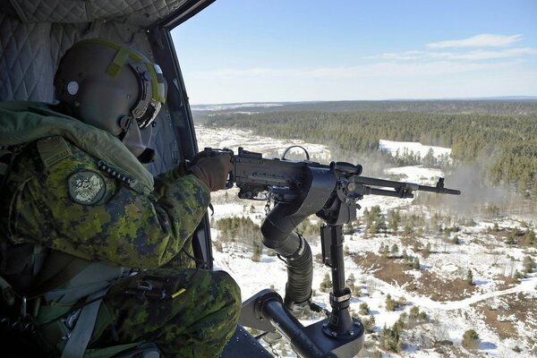 Soldat avec une mitraillette dans un avion au-dessus de la forêt