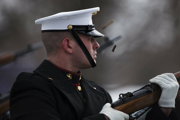 Soldat in weißer Schirmmütze mit Waffen