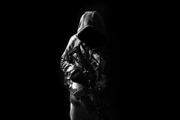 A hooded fighter with an assault rifle