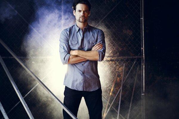 Shane west im blauen hemd auf einem Gitterhintergrund