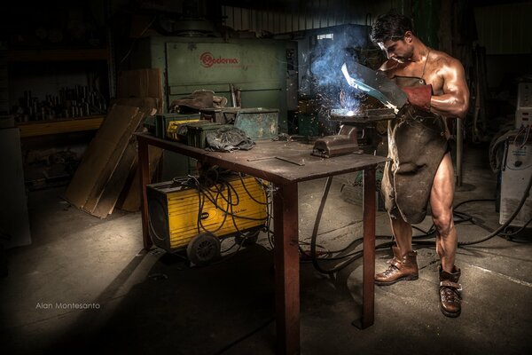 Guapo hombre desnudo con máquina de soldadura