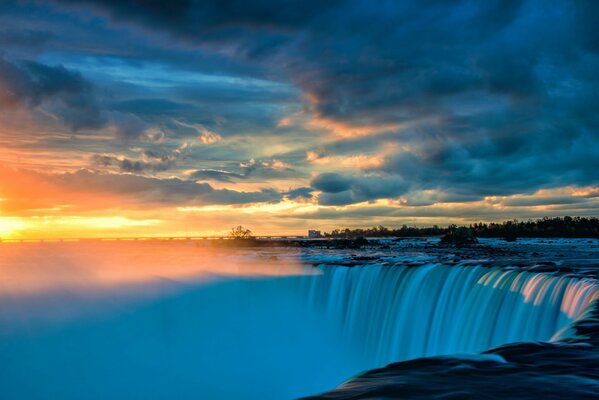 Paysage de cascade avec des nuages épais sur fond de coucher de soleil