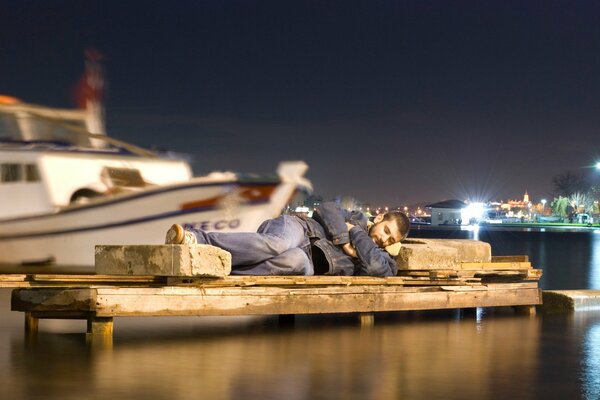 The situation with the man sleeping in the harbor on the rocks