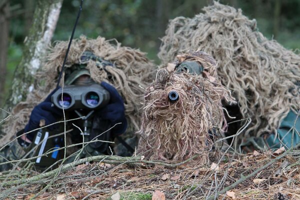 Sniper partners with rifles with camouflage in surveillance