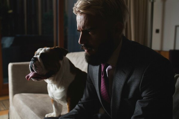 A man with a beard in a costume on the sofa with a dog