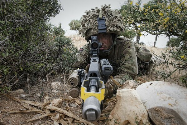 A soldier with a weapon in disguise takes aim