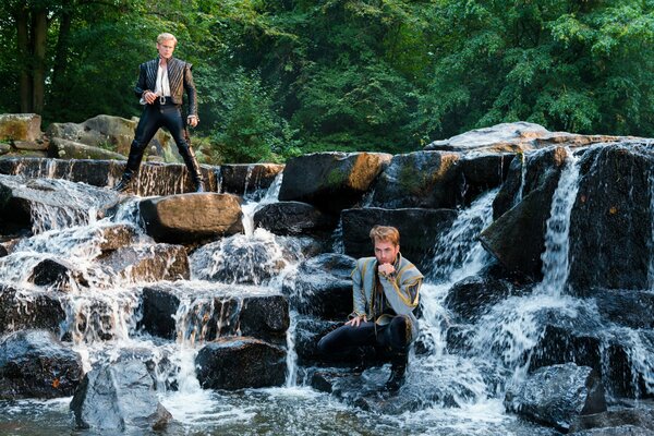 Schöne Jungs auf den Steinen des Wasserfalls