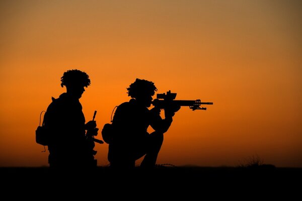 Cienie dwóch żołnierzy z bronią