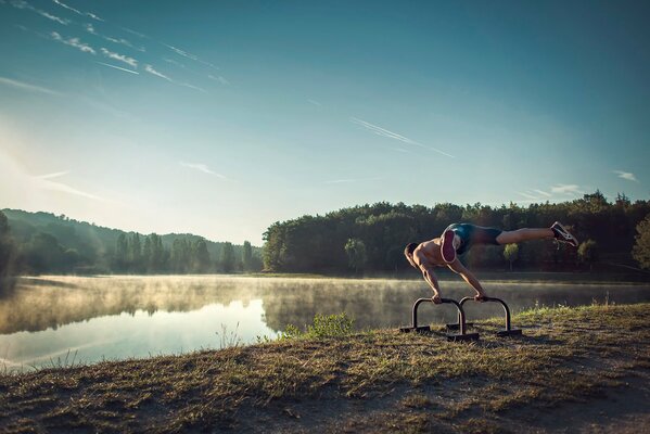 Atleta en la niebla de la mañana en el lago