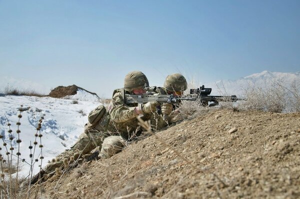 Soldats avec des armes assis dans une tranchée