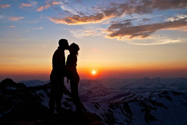 Pocałunek zakochanej pary o zachodzie słońca