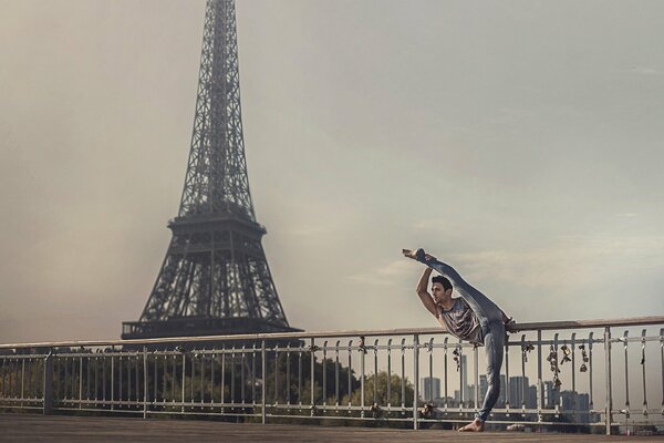 Balerun hace un estiramiento contra el fondo de la torre Eiffel