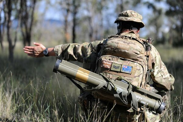 Soldado con armas en el ejército, desde atrás