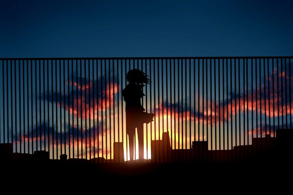 A girl in the city on the background of sunset