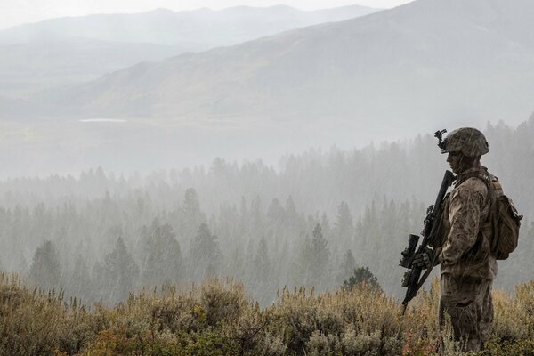 Soldat mit Waffen auf Waldhintergrund