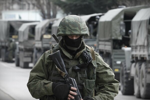 Militar en pasamontañas casco con ametralladora