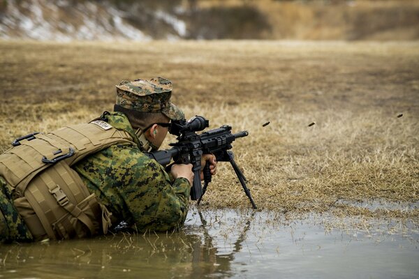 A US Marine soldier fires shots from an m27 automatic rifle